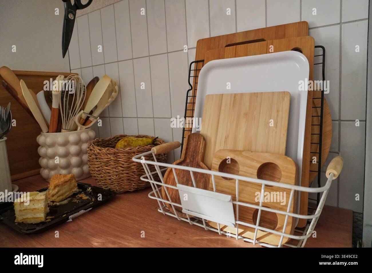 Eleganti utensili da cucina e taglieri in legno organizzati su un moderno piano di lavoro Foto Stock