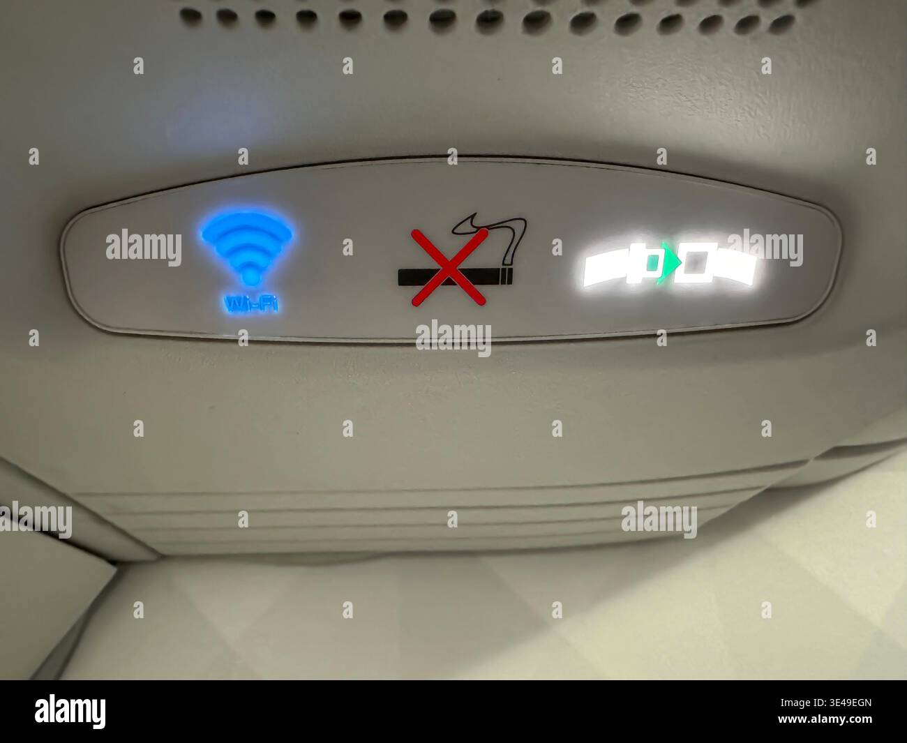 Trasporto notifica di avviso per l'aviazione in un aereo Airbus A220 WIFI non fumare e allacciare la cintura di sicurezza su un sedile Foto Stock
