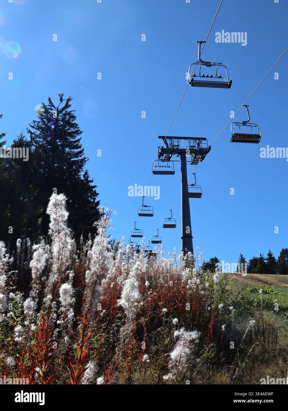 In primavera, in una giornata di sole, è in funzione uno skilift in una stazione sciistica in collina. Foto Stock