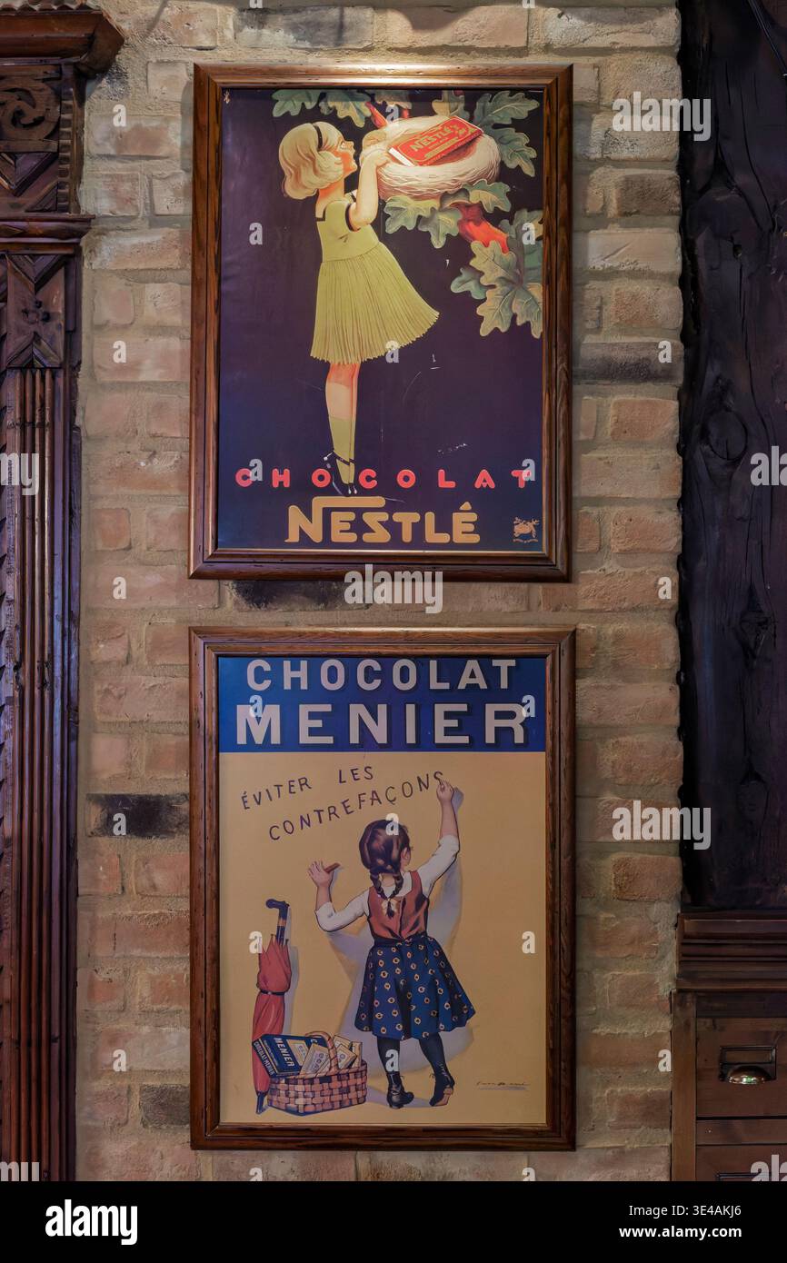 Due pubblicità di cioccolato vintage, per Nestlé e Menier, incorniciate e montate su un muro di mattoni a vista a Valladolid, Spagna. Foto Stock