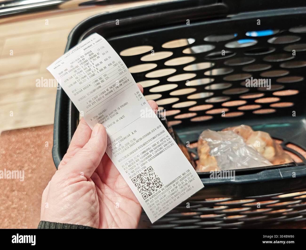Kirov, Russia - 3 gennaio 2026: Una persona è in possesso di una ricevuta della spesa di un viaggio di shopping che riporta i dettagli della conferma del pagamento e l'elenco degli articoli acquistati in Foto Stock