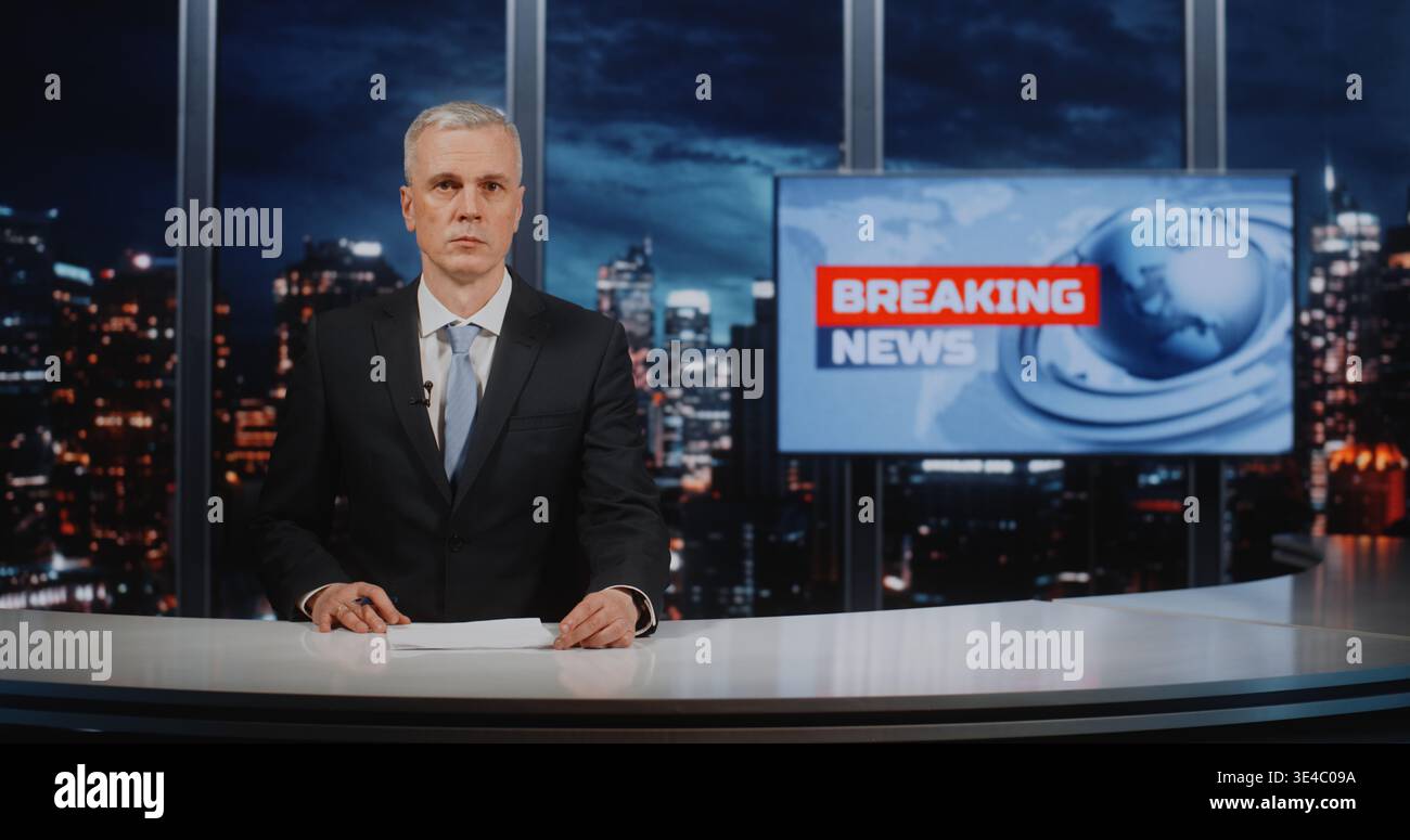 Confident male Reporter in abbigliamento formale che presenta la storia, tiene la penna e guarda la fotocamera. Giornalismo trasmesso con Breaking News Digital monitor e City skyscrapers. Digital Media Journalism. Foto Stock