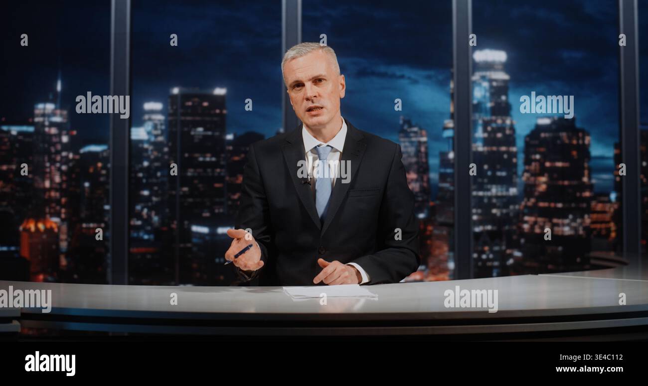Presentatore maschile sicuro di sé in abbigliamento formale che discute i problemi sociali, guarda la fotocamera e gesti con la penna, con sfondo Night City. Concetto di talk show e autorevole discorso pubblico. Foto Stock