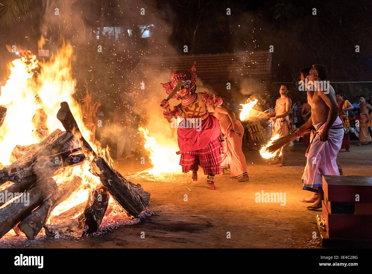 Drammatico spettacolo rituale di danza del fuoco Theyyam di notte in un villaggio vicino a Kannur, Kerala, India Foto Stock
