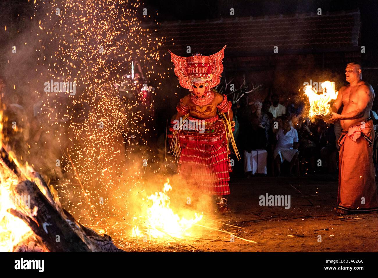 Drammatico spettacolo rituale di danza del fuoco Theyyam di notte in un villaggio vicino a Kannur, Kerala, India Foto Stock