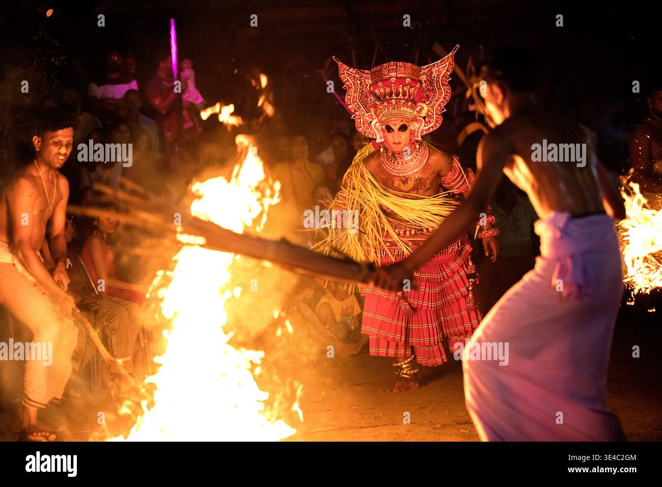 Drammatico spettacolo rituale di danza del fuoco Theyyam di notte in un villaggio vicino a Kannur, Kerala, India Foto Stock