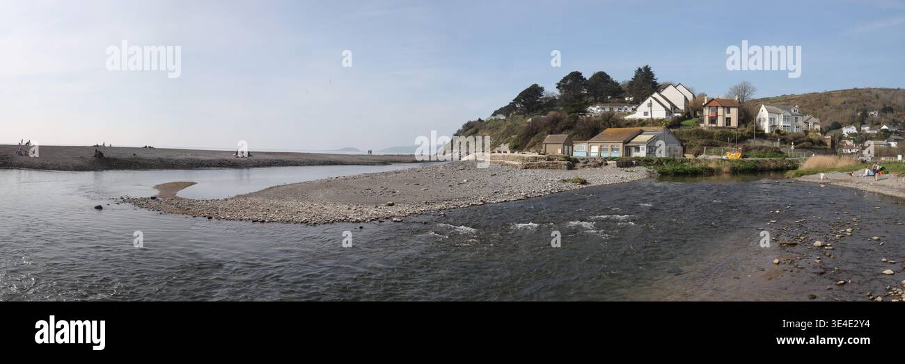 Foto panoramica del tortuoso fiume Seaton mentre attraversa la spiaggia di Seaton nella Cornovaglia meridionale. Marzo 2026 . Il caffè sulla spiaggia è ancora chiuso. Foto Stock