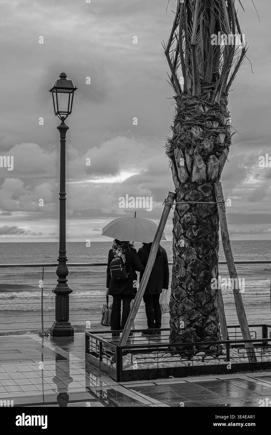 gli amanti si fermano per ammirare il mare dopo una tempesta Foto Stock