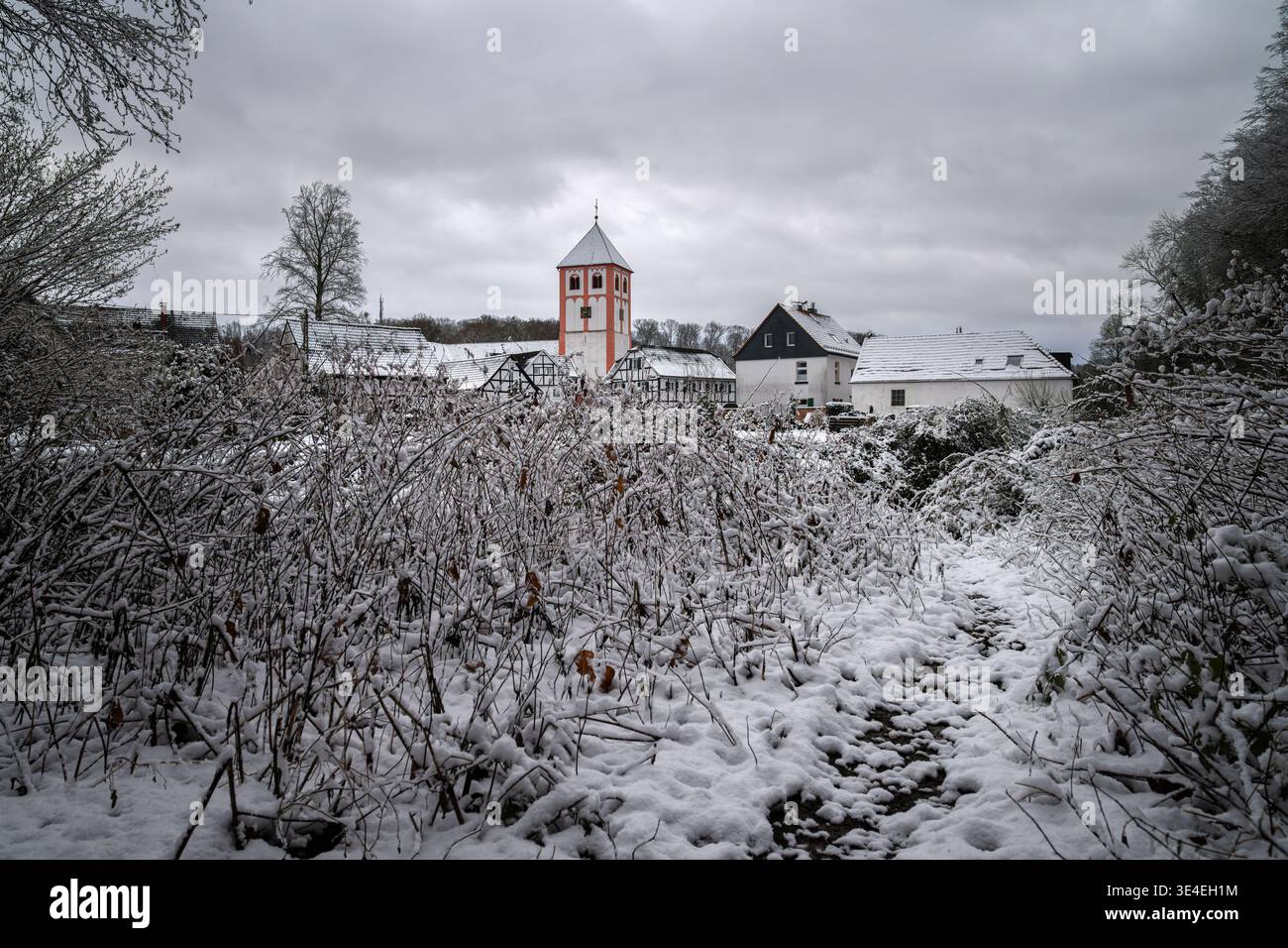 Centro del villaggio di Odenthal con chiesa parrocchiale e vecchi edifici in inverno, Bergisches Land, Germania Foto Stock