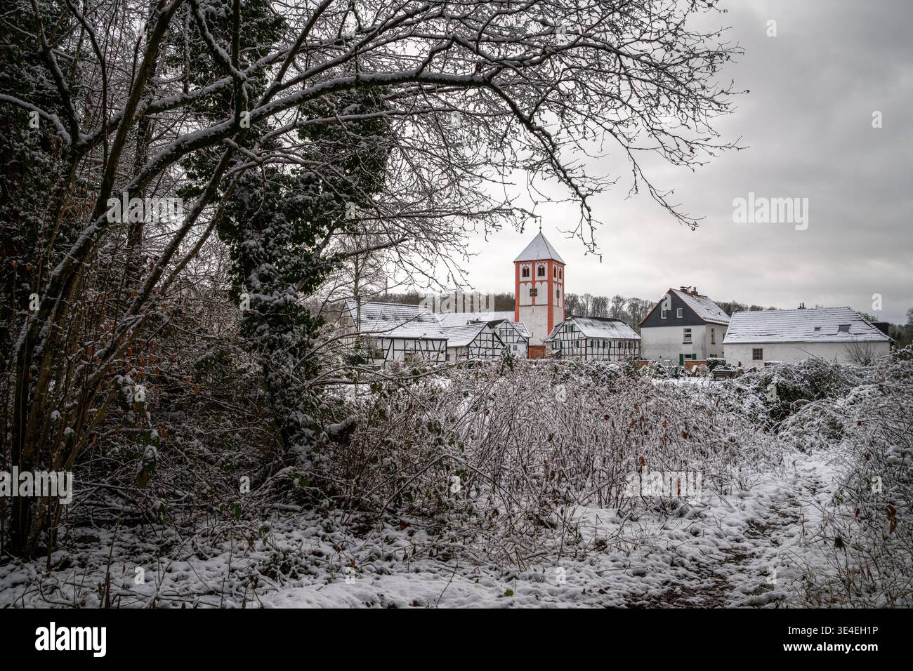 Centro del villaggio di Odenthal con chiesa parrocchiale e vecchi edifici in inverno, Bergisches Land, Germania Foto Stock