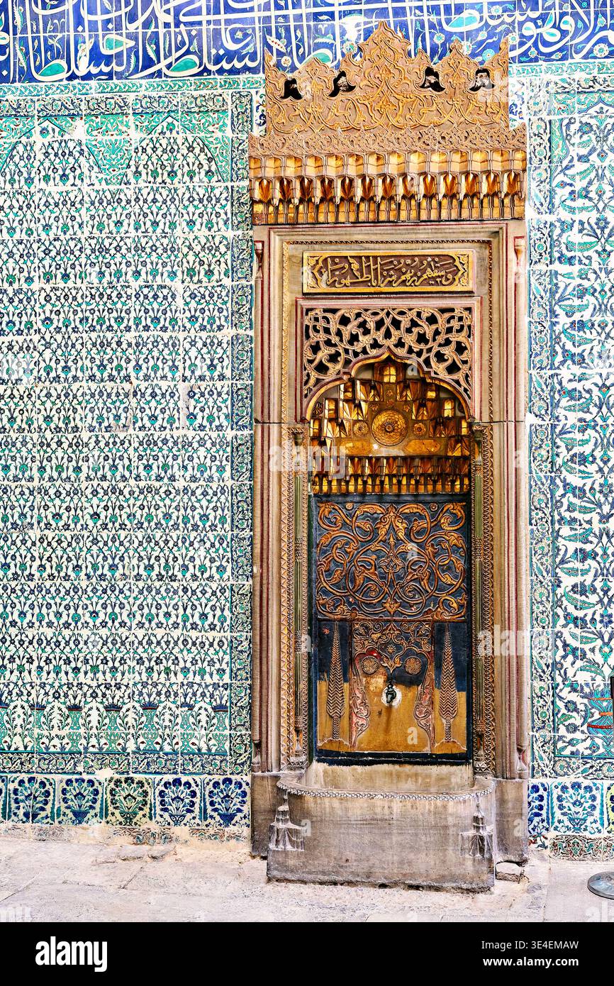I visitatori notano una storica fontana all'interno del Palazzo Topkapi di Istanbul. La fontana presenta disegni intricati e piastrelle colorate. Foto Stock
