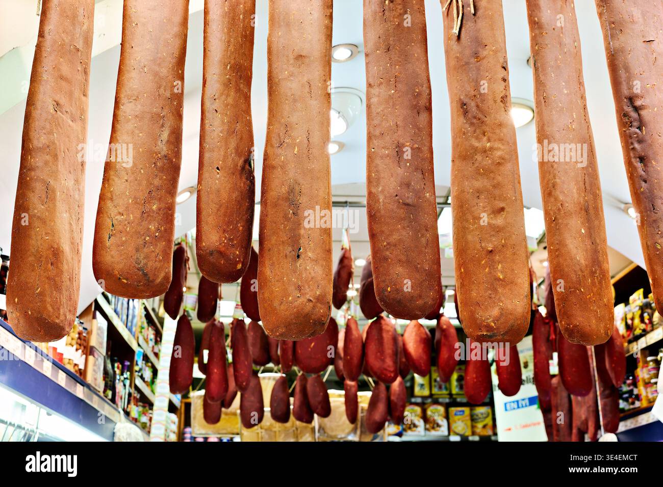 I visitatori esplorano il Grand Bazaar di Istanbul. Vengono esposti vari prodotti alimentari, appesi dall'alto, che mostrano offerte culinarie locali. Foto Stock