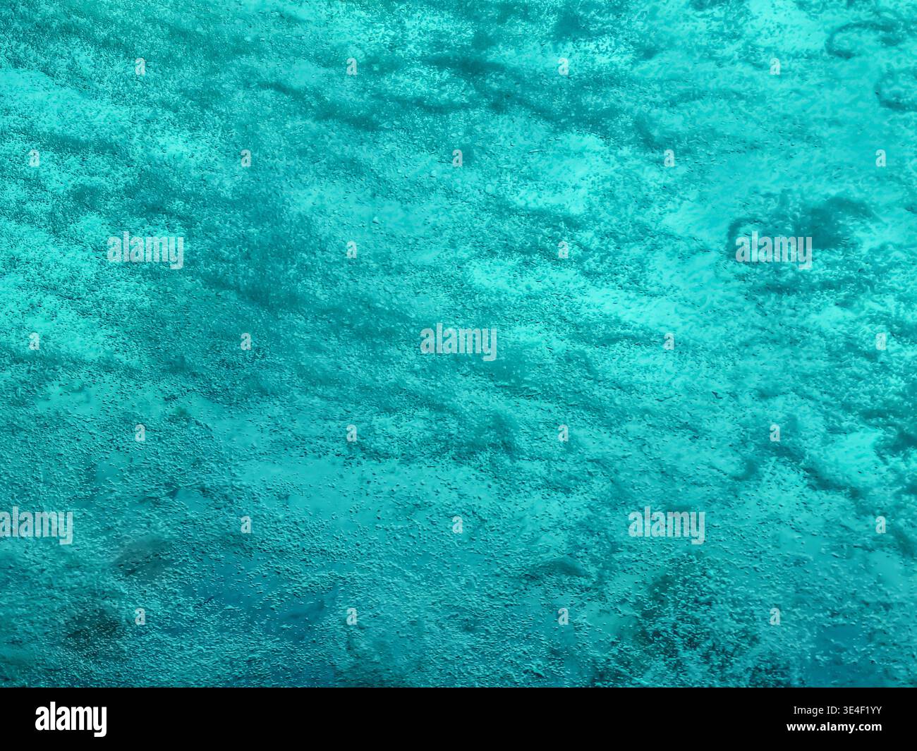 Superficie d'acqua espansa in primo piano. Molte bolle d'aria sullo sfondo dell'acqua turchese. Bellissimo sfondo astratto in acqua Foto Stock