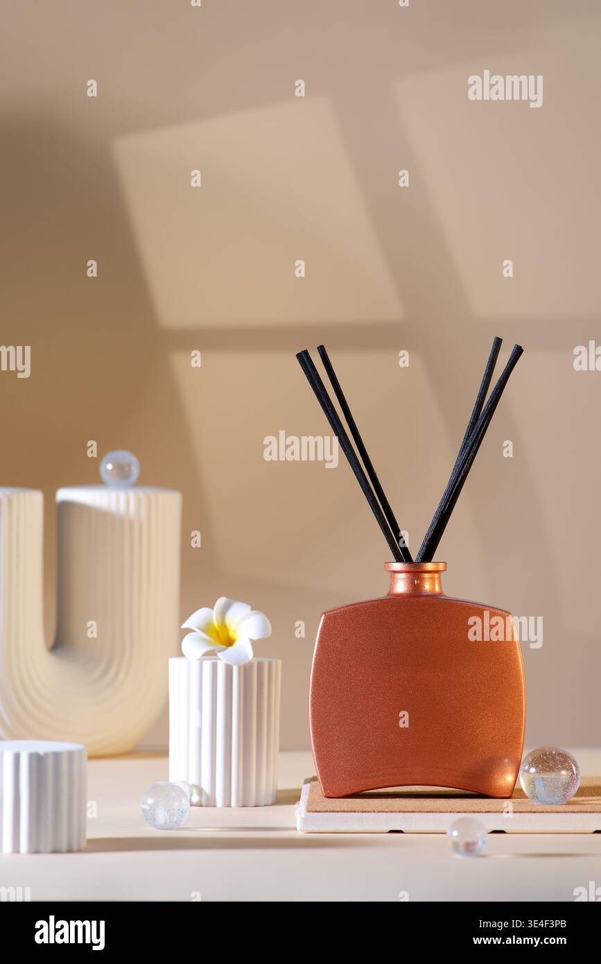 Diffusore reed con bastoncini su sfondo beige. Foto Stock