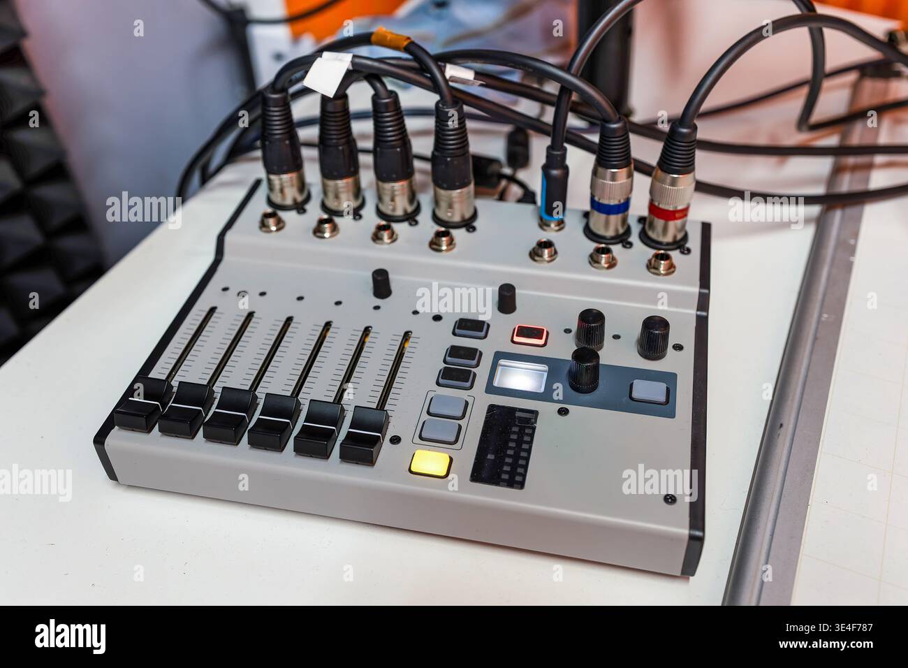 Visione ad angolo alto del mixer audio compatto utilizzato per la produzione di radio e podcast. Più ingressi XLR e jack collegati. L'unità è dotata di deflettori scorrevoli e. Foto Stock