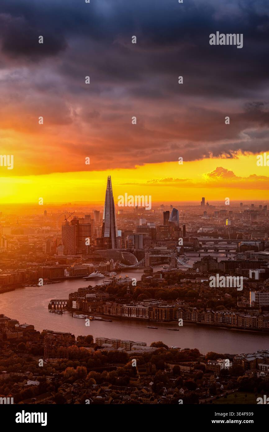 Splendido tramonto autunnale dietro lo skyline urbano di Londra, Inghilterra, con sole, nuvole e pioggia Foto Stock