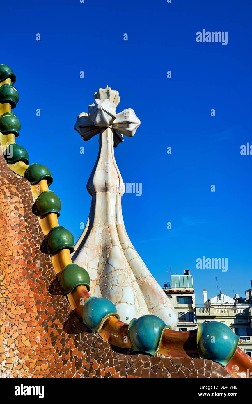 I dettagli di Casa Batllo sono mostrati contro un cielo blu a Barcellona. Questo sito attrae molti visitatori ogni giorno alla ricerca del lavoro di Gaudí. Foto Stock