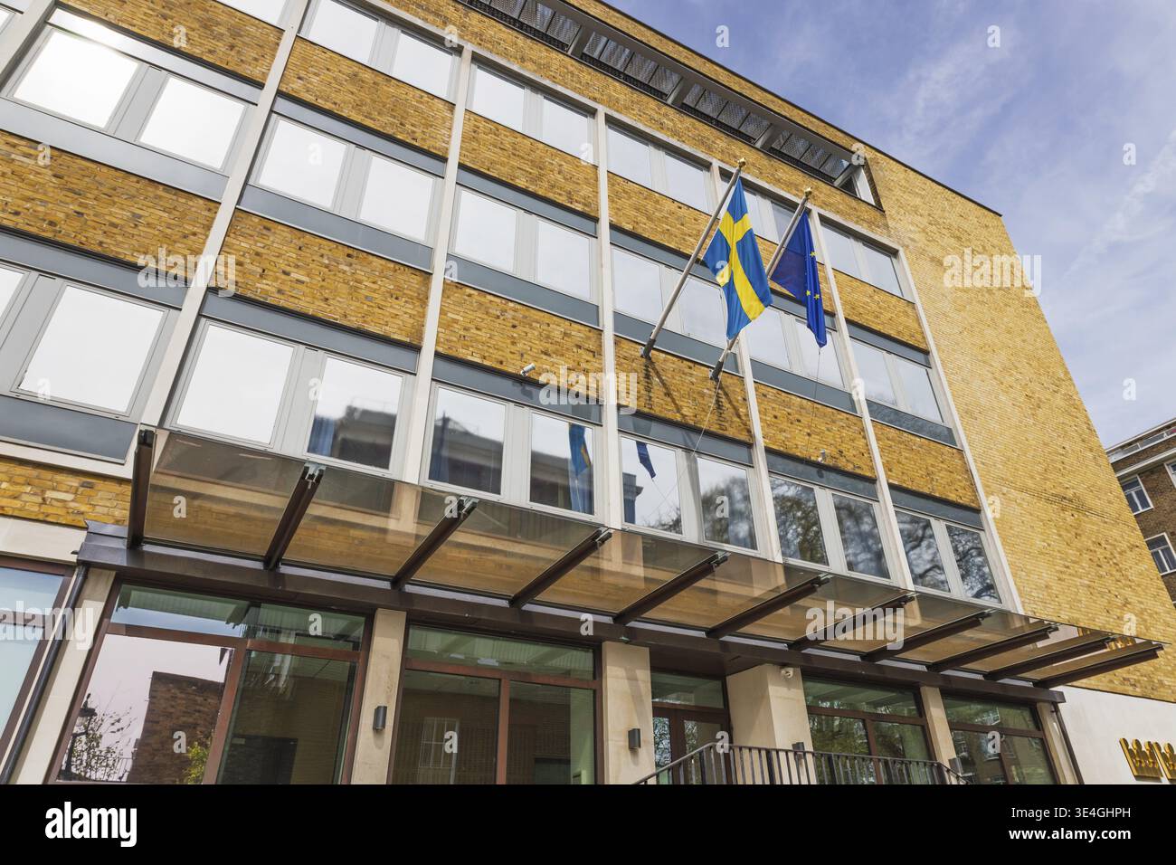 L'Ambasciata di Svezia presenta una moderna facciata in vetro, esterno in mattoni e bandiera svedese. Londra, Regno Unito, 14 aprile 2024 Foto Stock