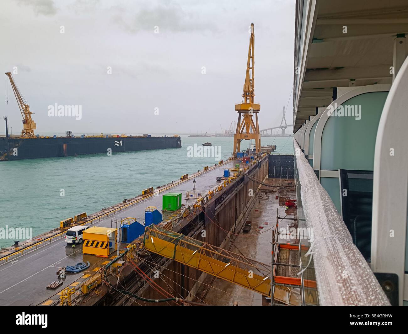 Vista dal ponte delle navi sulla banchina del porto con gru e operazioni di carico, scena dell'industria marittima con logistica e infrastrutture di trasporto marittimo. Foto Stock