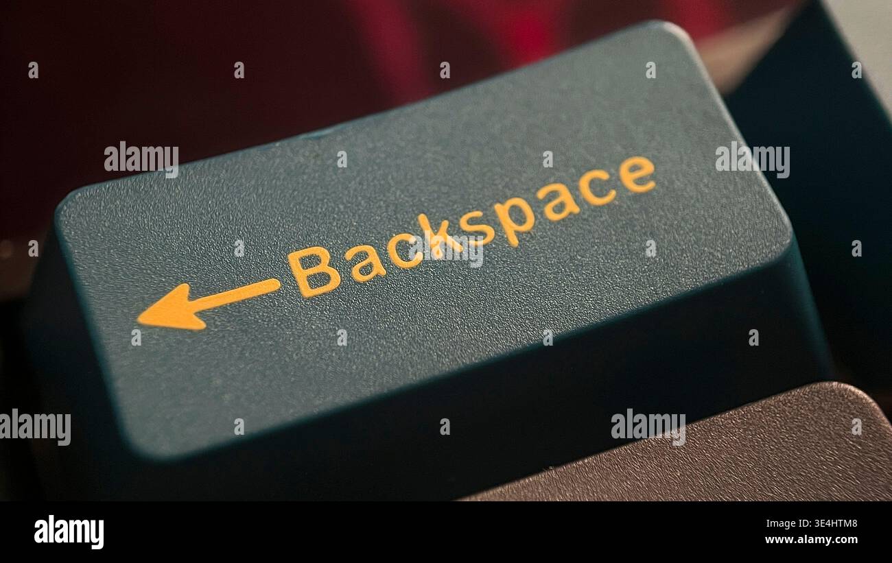 Primo piano del tasto di backspace della tastiera del computer con testo giallo e freccia Foto Stock