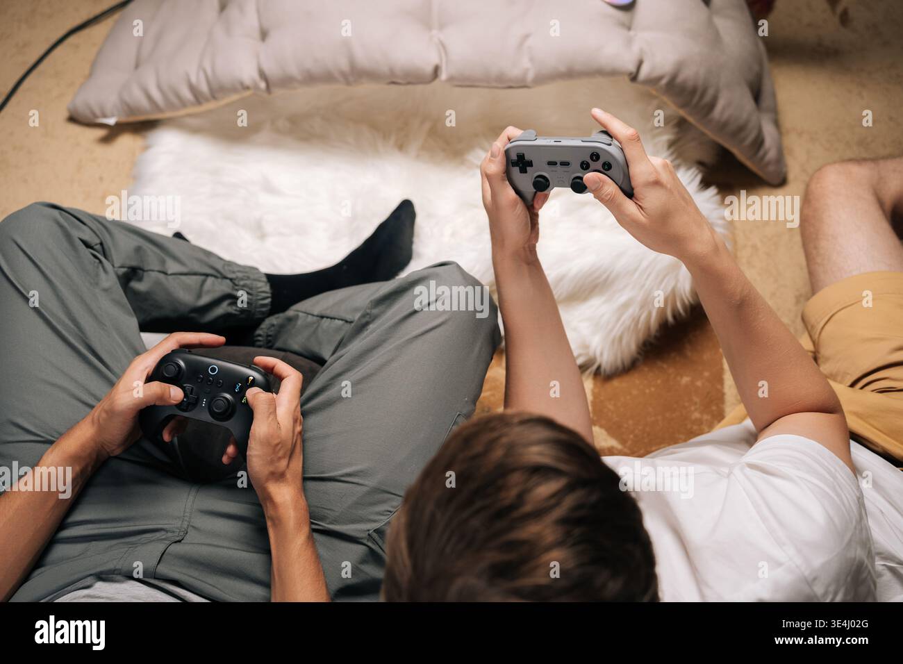 Primo piano di due amici maschi che giocano insieme a casa, si divertono con i videogiochi per console durante il tempo libero, si divertono e si rilassano durante la condivisione Foto Stock