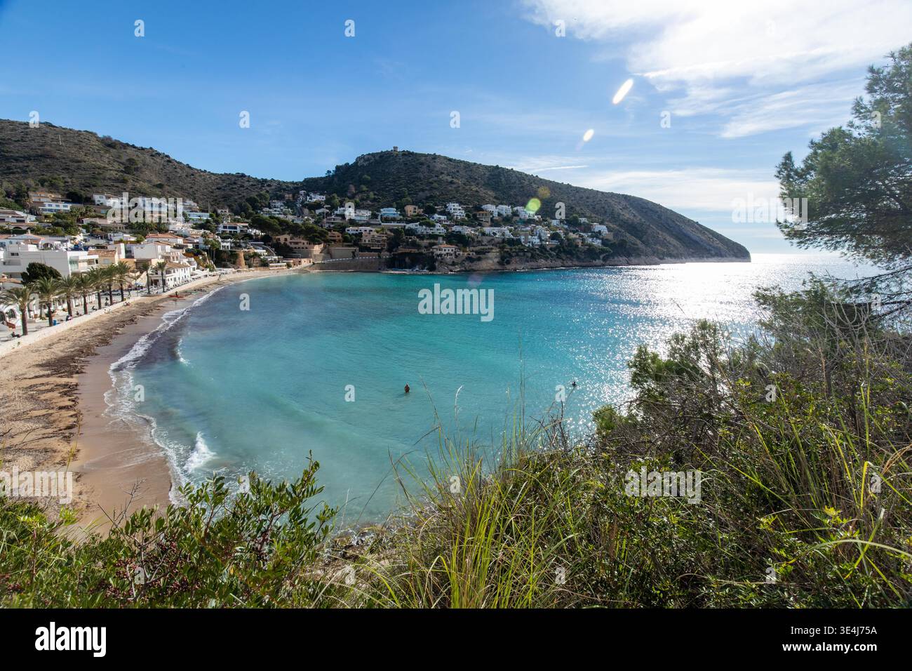 Vista panoramica della baia di Moraira sulla Costa Blanca, Alicante, con una spiaggia sabbiosa, mare Mediterraneo turchese, ville in collina e calmo sole estivo Foto Stock