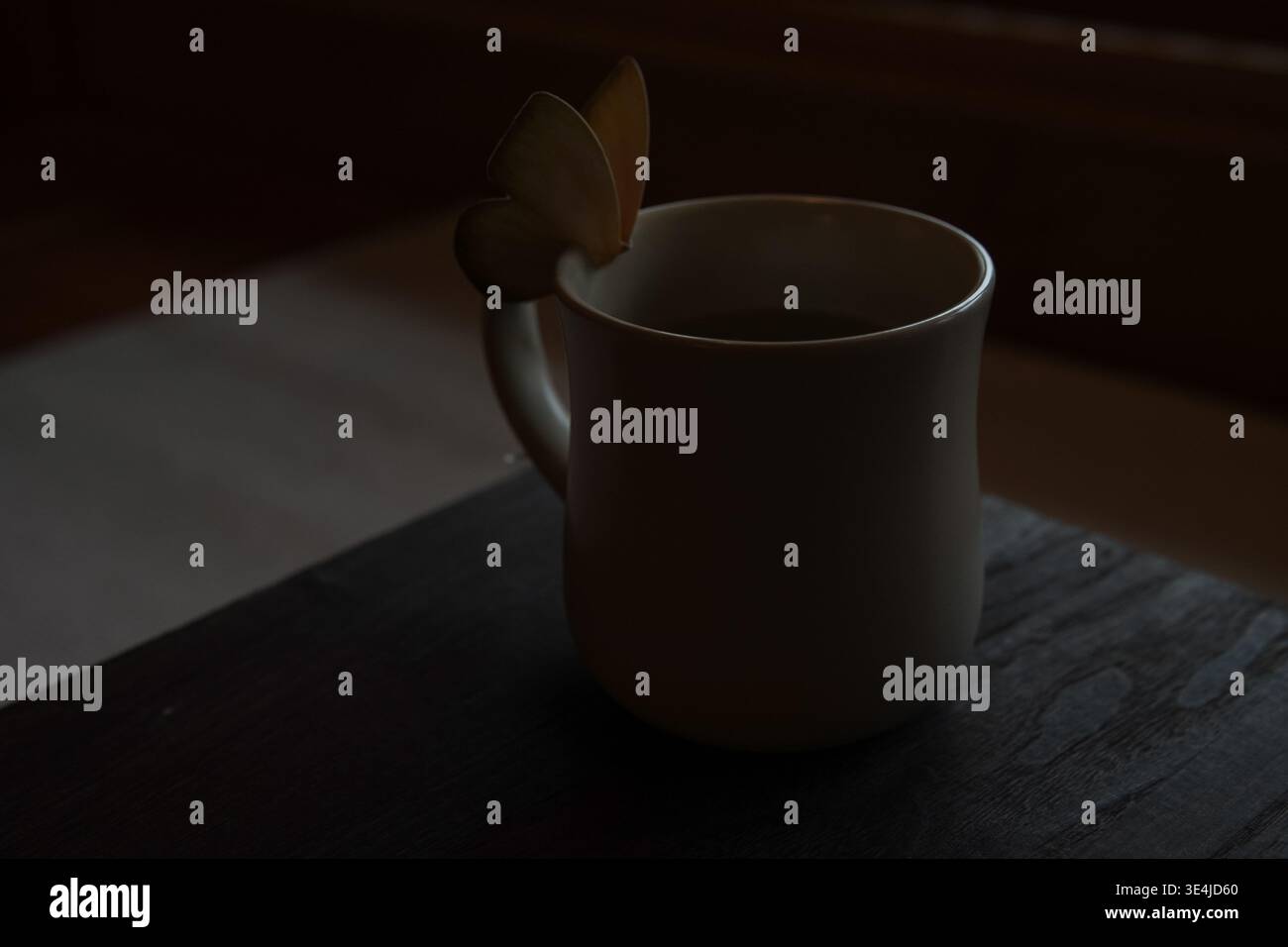 Tazza in ceramica bianca con decorazione a farfalla in Moody Light Foto Stock