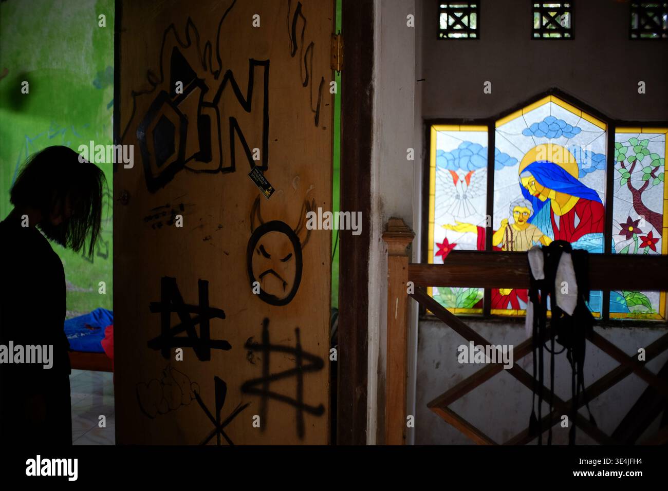 Atmosfera all'interno della casa abbandonata, vandalismo sulla porta, c'è una figura d'ombra nera, la vibrazione è spaventosa Foto Stock