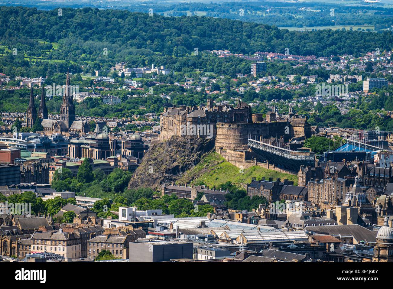 Vista panoramica del Castello di Edimburgo arroccato su Castle Rock con Arthur's Seat che sorge dietro lo storico skyline della città, colline verdeggianti e edifici in pietra Foto Stock