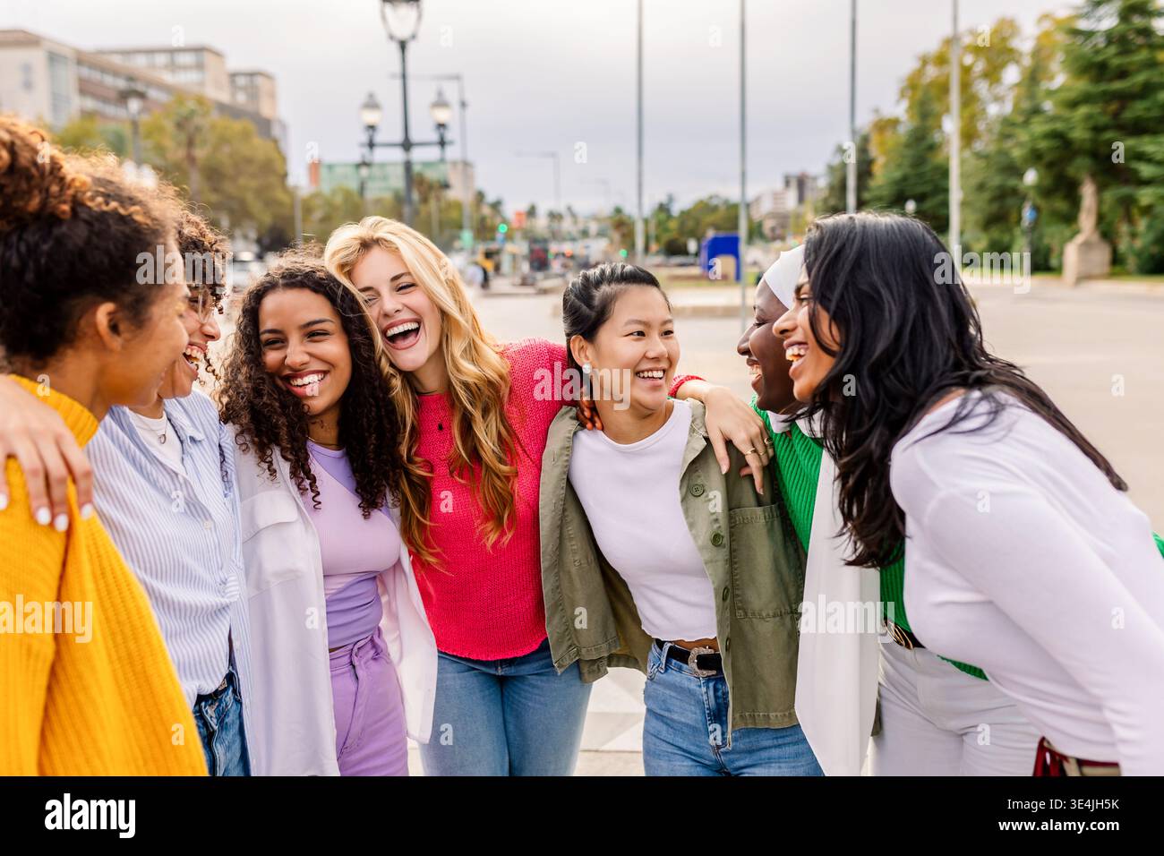Diverse giovani donne in piedi vicino e sorridenti all'aperto Foto Stock