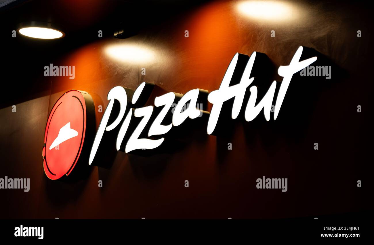 Varsavia, Polonia - 29 dicembre 2024: Grande cartello con il logo della Pizza Hut all'entrata illuminazione notturna Foto Stock