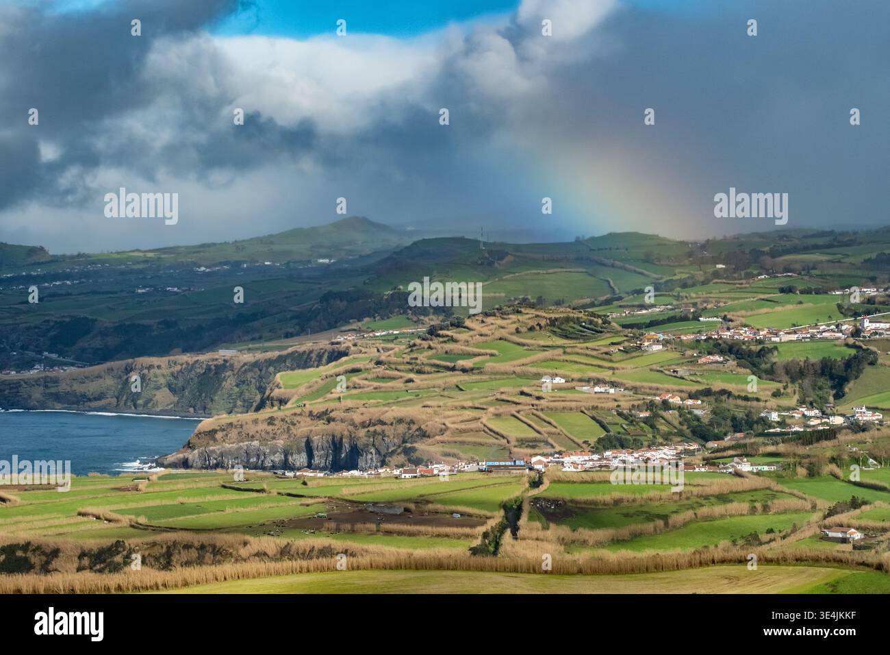 Arcobaleno sui verdi pascoli e le scogliere atlantiche, l'isola di Sao Miguel, le Azzorre Foto Stock