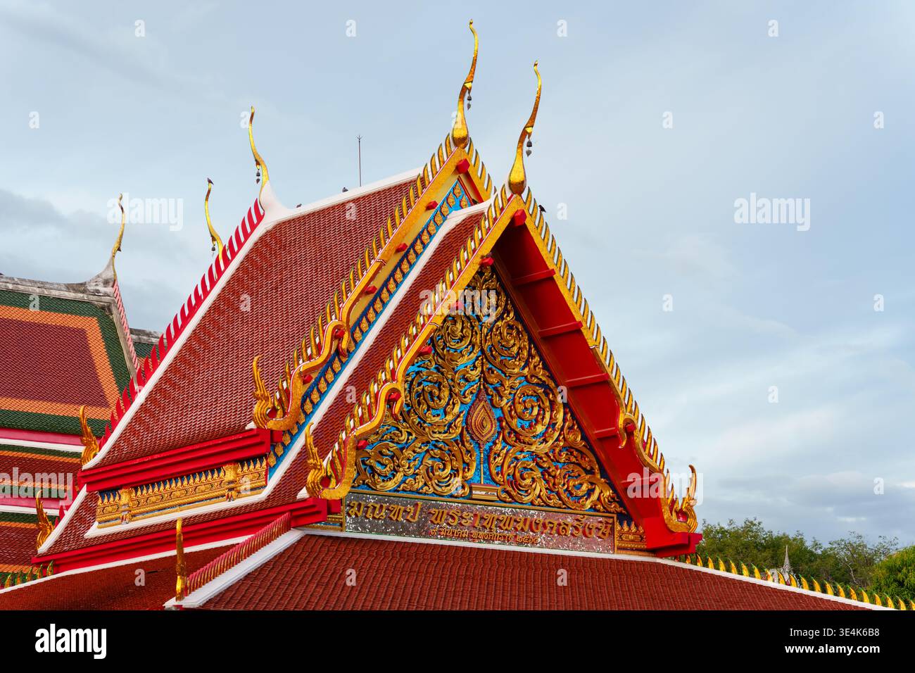 Kanchanaburi, Thailandia - 23 novembre 2024: I dettagli ornati del tetto e del tetto del tempio buddista Wat Thewa Sangkharam sono visti contro il cielo. Foto Stock