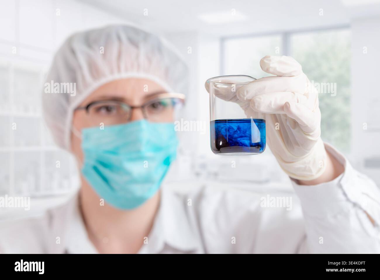 Becher per scienziati con soluzione chimica blu e reazione alla sostanza scura, analisi di laboratorio e ricerca scientifica Foto Stock