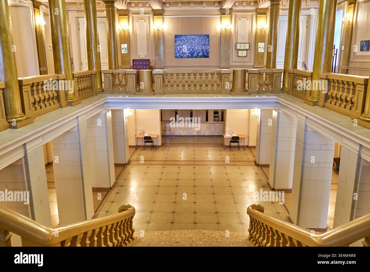 Eleganti interni storici di un grandioso edificio caratterizzato da un'ampia scalinata con balaustre e ringhiere dorate ornamentali. La vista ne acquisisce due Foto Stock