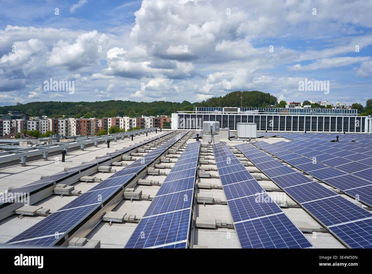 File di pannelli solari fotovoltaici blu installati su un tetto commerciale piatto con sistemi di montaggio di zavorre in calcestruzzo. Le caratteristiche di installazione Foto Stock