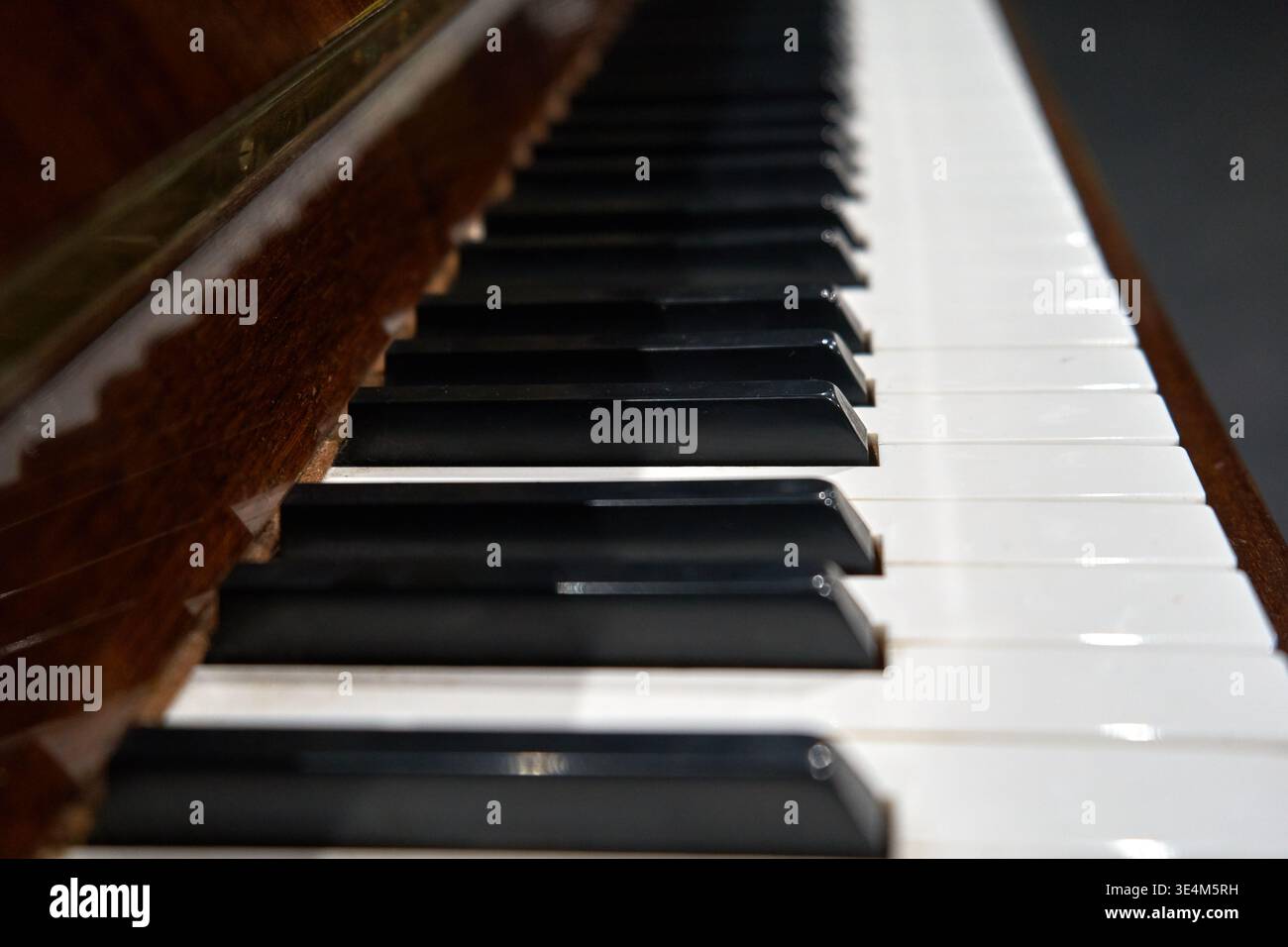 Vista in diagonale ravvicinata di una tastiera a pianoforte che mostra il classico schema dei tasti in bianco e nero. La fotografia cattura la superficie lucida di Foto Stock