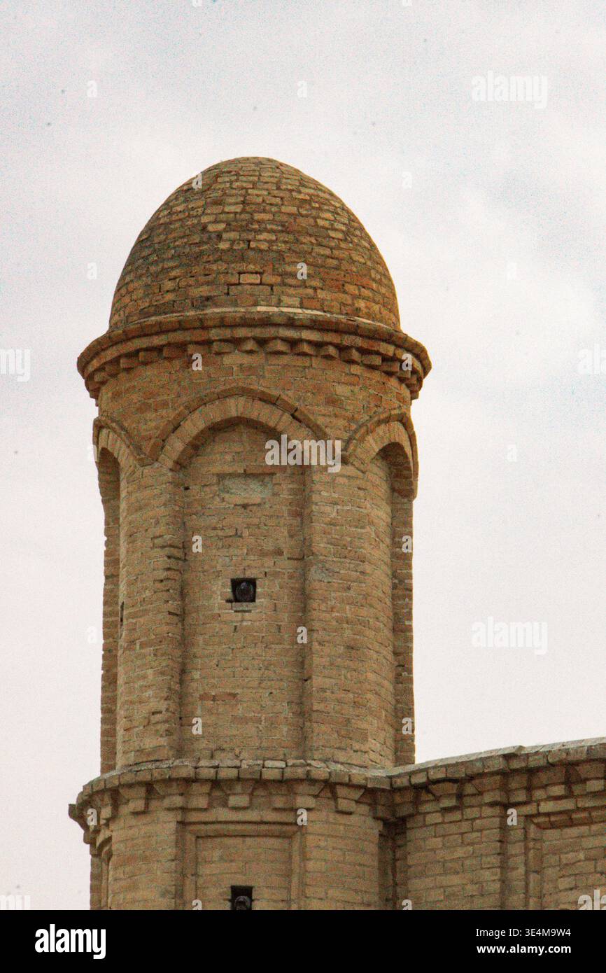 Dettaglio architettonico estetico di un'antica torre a cupola con intricate pietre contro un cielo nuvoloso Foto Stock