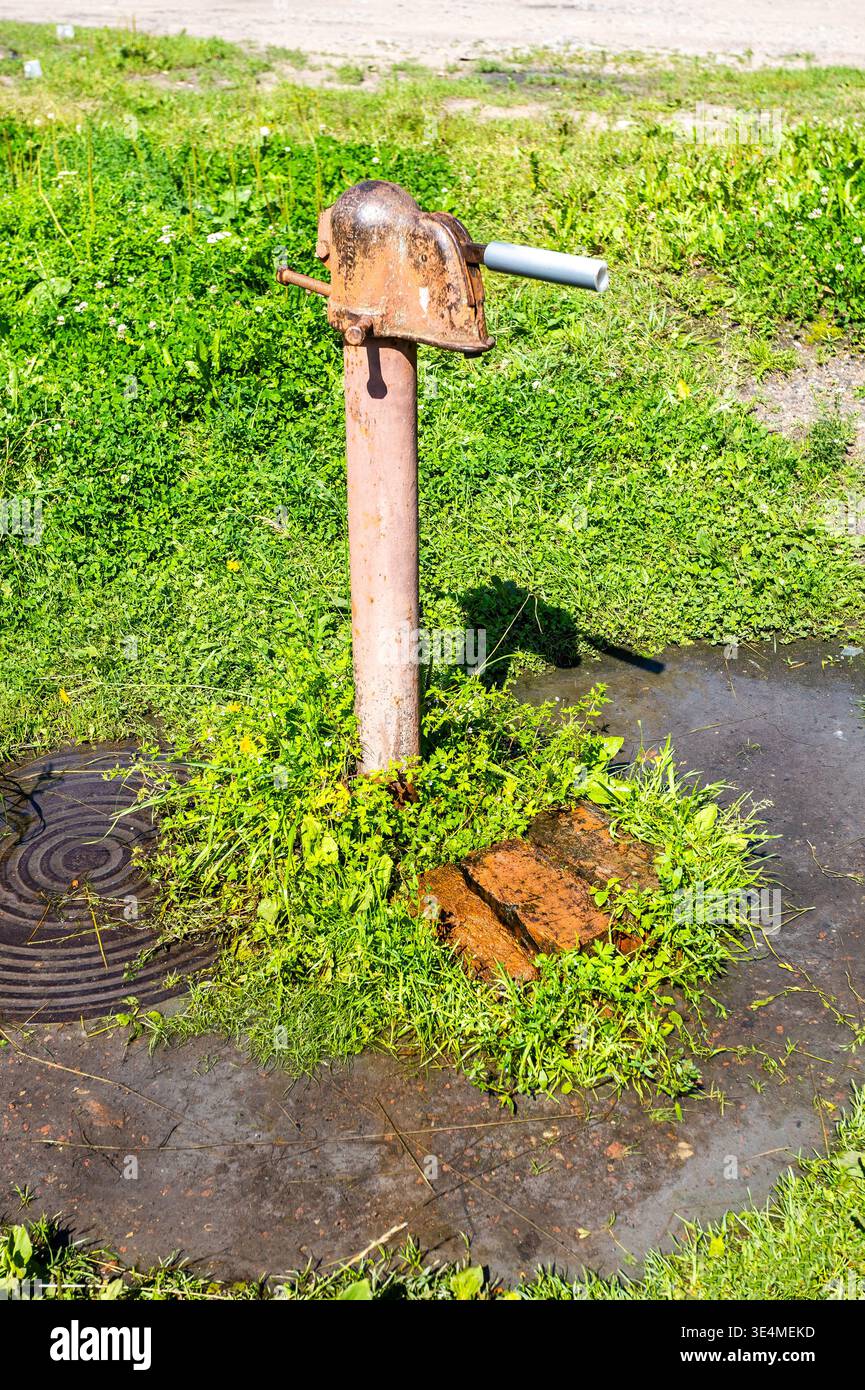 Vecchia strada libera. Punto di ritiro vecchia pompa d'acqua in metallo in campagna in estate Foto Stock