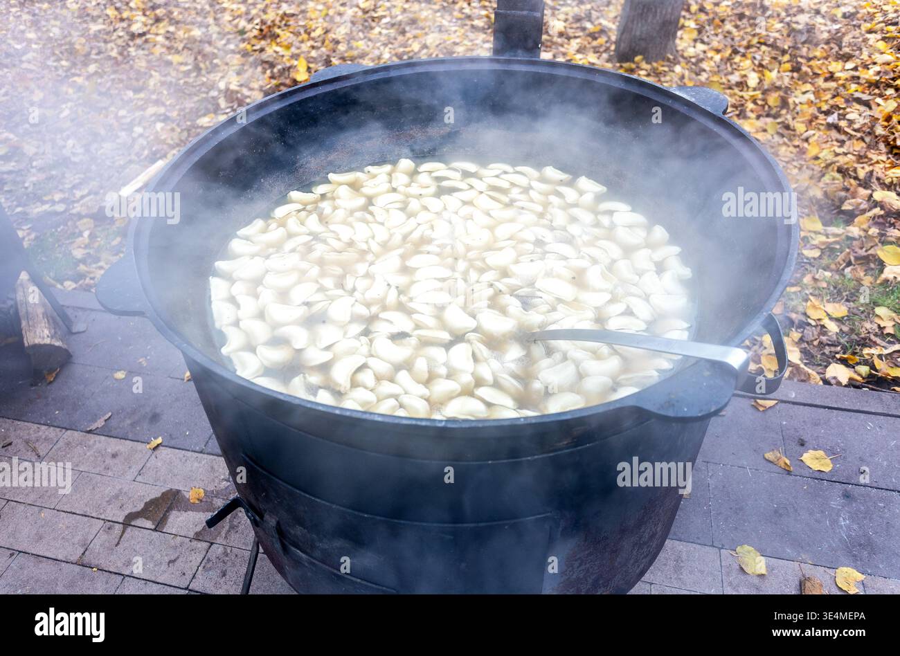 Gnocchi con carne bolliti in un grande calderone all'aperto Foto Stock