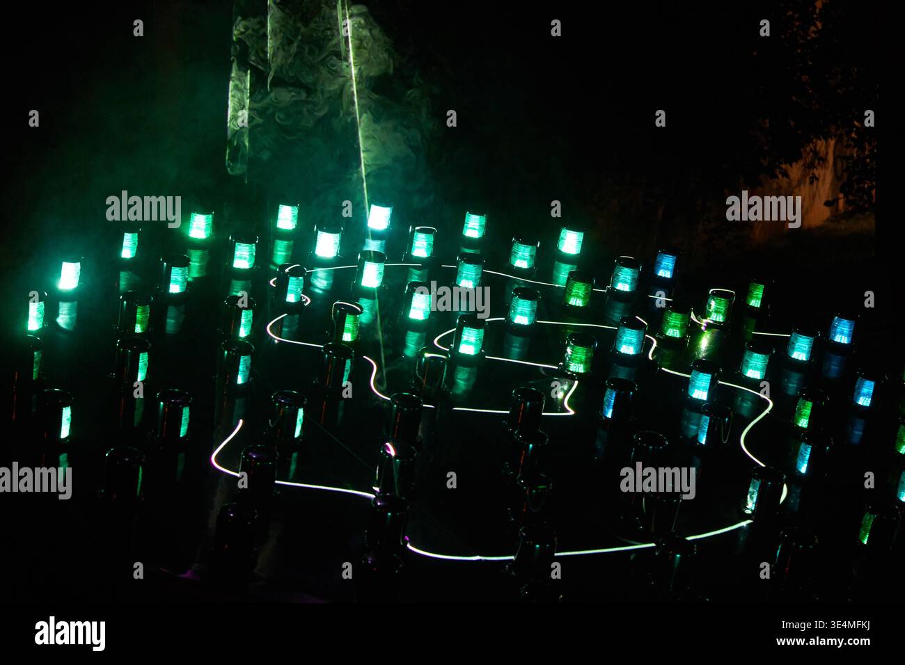 Un'affascinante installazione di arte luminosa all'aperto fotografata di notte, caratterizzata da numerosi apparecchi di illuminazione cilindrici disposti in motivi geometrici Foto Stock