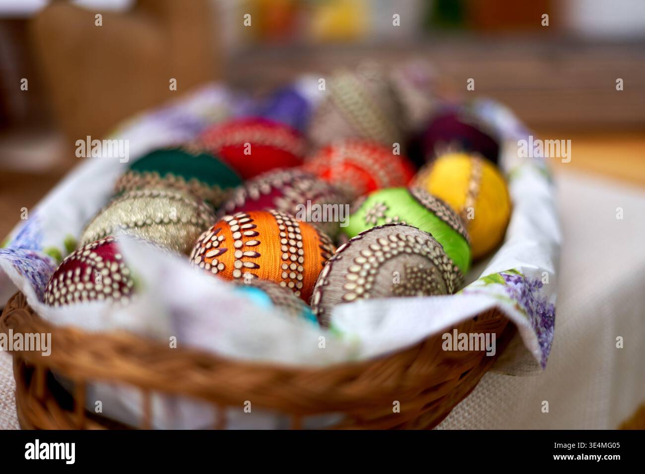Un cestino di vimini pieno di uova di Pasqua colorate decorate a mano con intricati motivi tradizionali, tra cui punti, linee e disegni geometrici Foto Stock