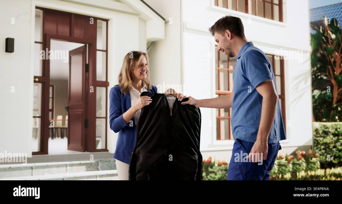 Joyful Delivery Person presenta un cappotto appena lavato in un servizio di pulizia professionale Foto Stock