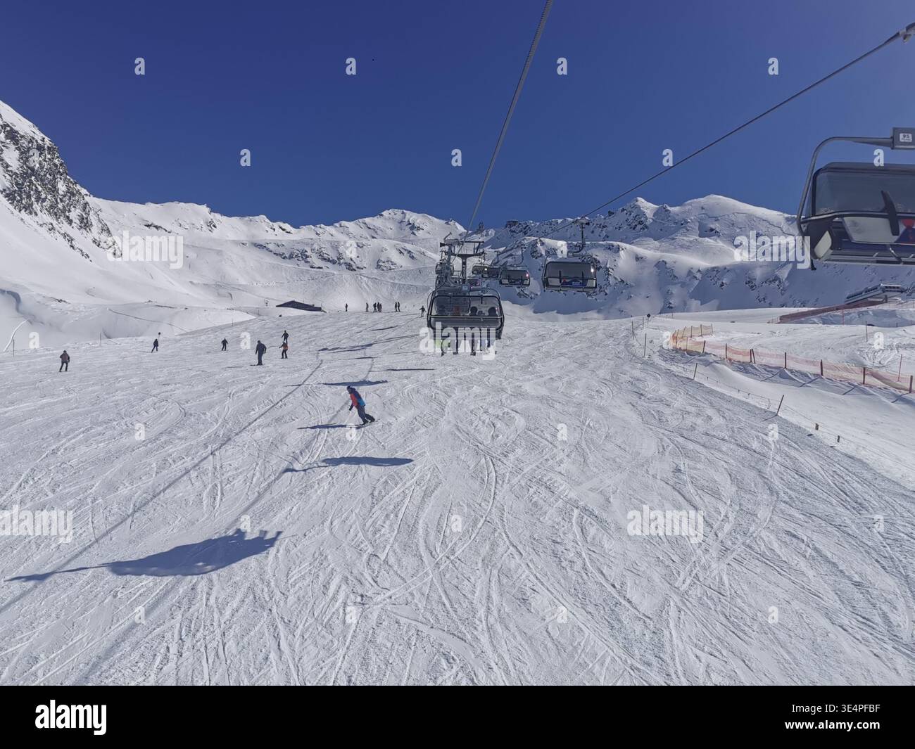 Cieli limpidi e neve fresca sulla pista blu di Hochgurgl, Wurmkogl i, che offre un terreno dolce e un paesaggio panoramico delle montagne di Ötztal in perfetta luce invernale. - Immagine stock catturata con smartphone