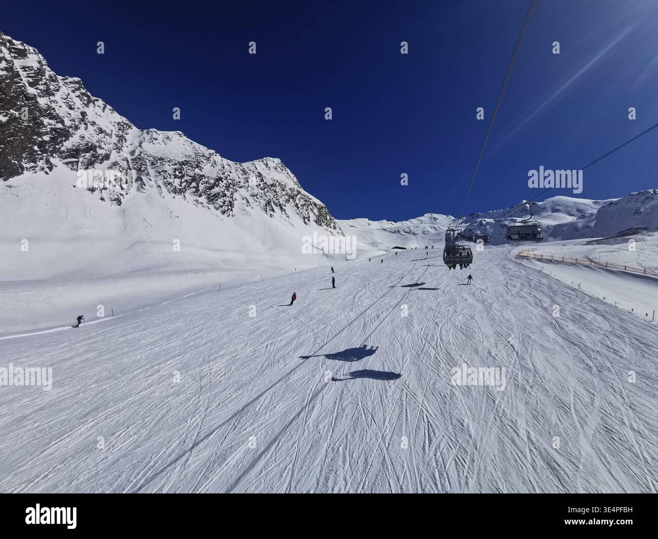 Cieli limpidi e neve fresca sulla pista blu di Hochgurgl, Wurmkogl i, che offre un terreno dolce e un paesaggio panoramico delle montagne di Ötztal in perfetta luce invernale. - Immagine stock catturata con smartphone