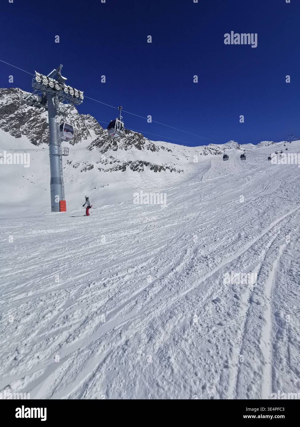 Cieli limpidi e neve fresca sulla pista rossa di Hochgurgl 30 alla Schermerbahn. Bellezza alpina e perfette condizioni sciistiche delle Alpi Ötztal Austria. - Immagine stock catturata con smartphone