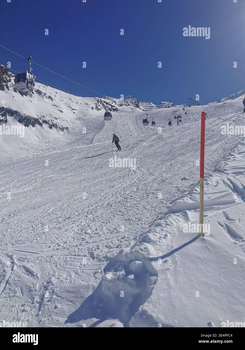 Cieli limpidi e neve fresca sulla pista rossa di Hochgurgl 30 alla Schermerbahn. Bellezza alpina e perfette condizioni sciistiche delle Alpi Ötztal Austria. - Immagine stock catturata con smartphone