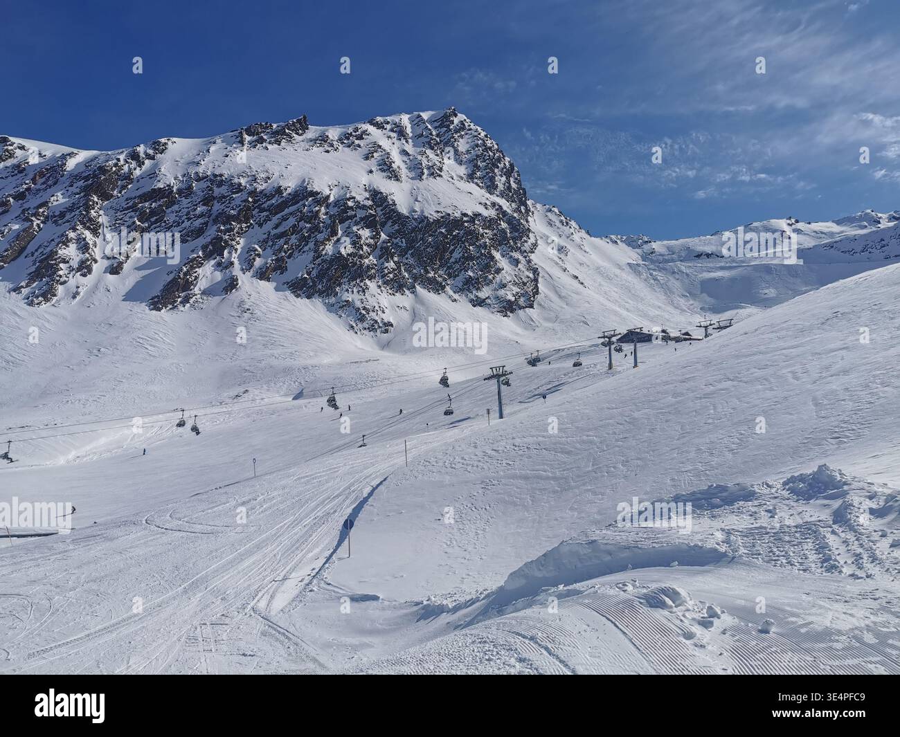Cieli limpidi e neve fresca sulla pista blu di Hochgurgl, Wurmkogl i, che offre un terreno dolce e un paesaggio panoramico delle montagne di Ötztal in perfetta luce invernale. - Immagine stock catturata con smartphone