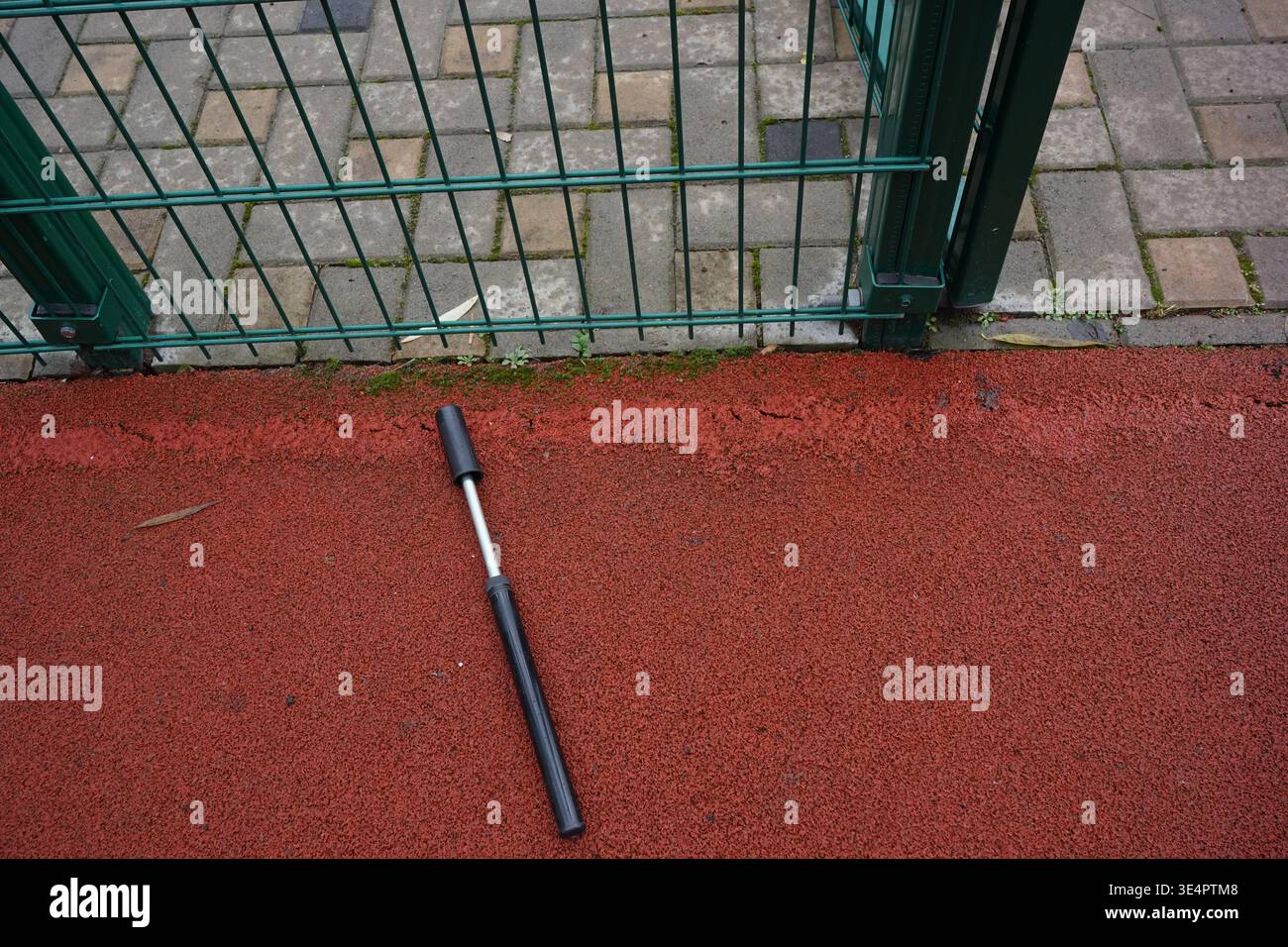 La pompa per biciclette sul campo sportivo Red Sports Court la pompa per biciclette compatta si trova su un terreno sportivo. Foto Stock