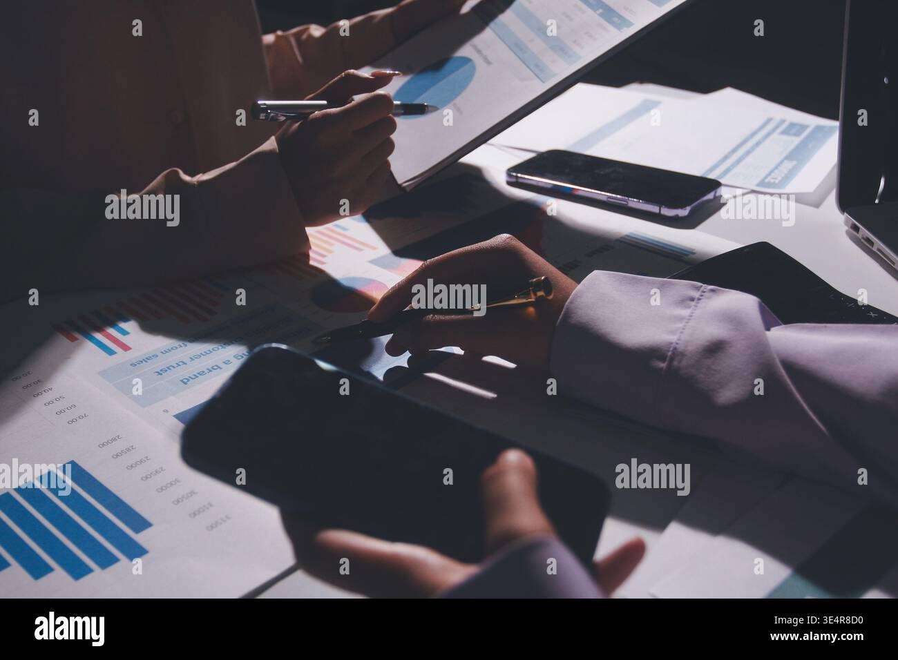 Tabella riportata sopra con documenti finanziari, grafici e big data durante la riunione di lavoro di squadra con il team di contabilità o marketing che discute di budget, strategia o crescita d Foto Stock